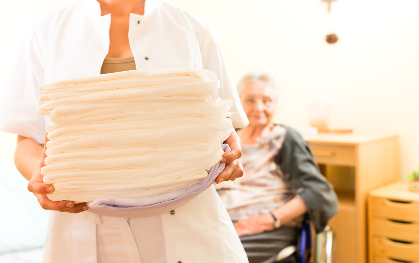 A person holding a stack of folded towels