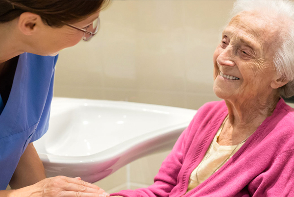 A caregiver smiling at an elderly patient