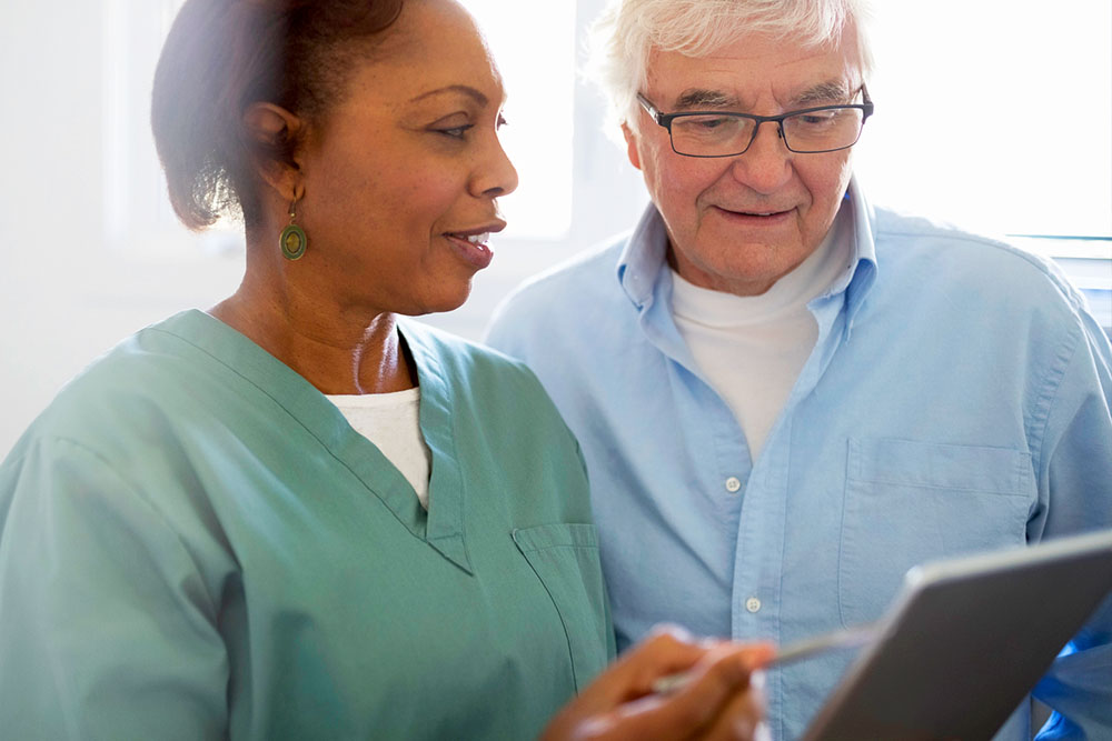 Speak their language: 8 tips to help improve health literacy Nurse speaking with elderly male patient.