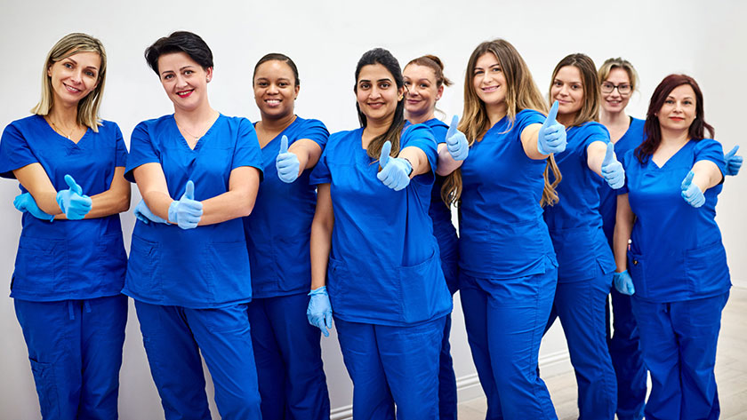 Line of caregivers giving thumbs-up
