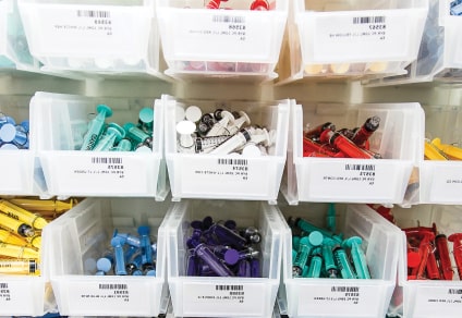 Image depicting Riverside Healthcare’s improve care quality case study Color-coded bins holding medical supplies