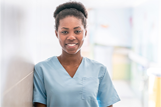 Woman in light blue scrubs smiling