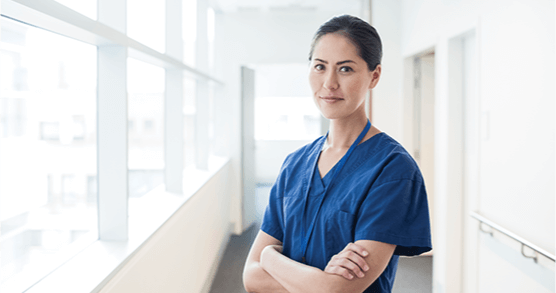 Woman in blue scrubs with arms crossed