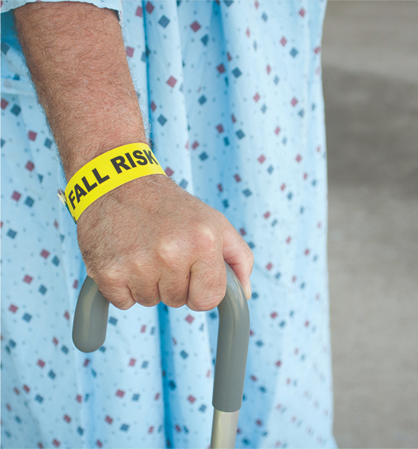 Falls Risk Hero Image 1 (1) An arm with yellow fall risk band on wrist and a cane