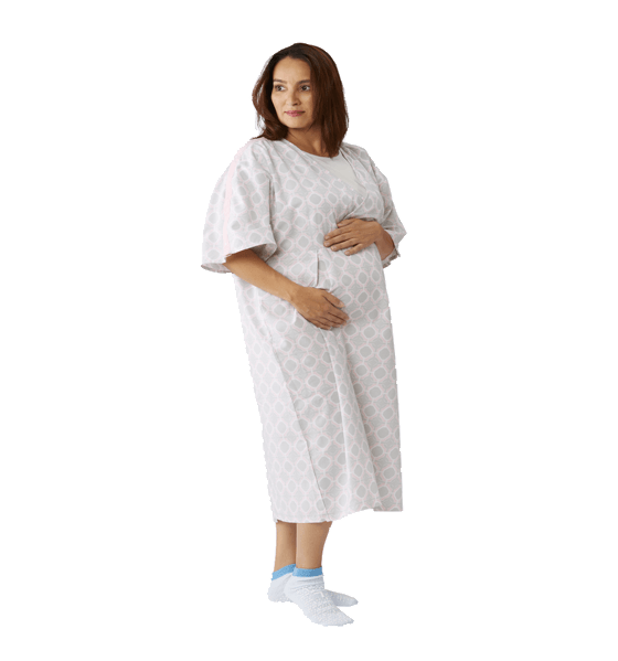 Photo of a woman standing in a patient gown with her hands cradling her pregnant belly