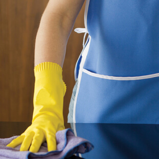 cleaning-process EVS worker's gloved hand cleaning a table