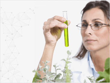 Scientist looking at beaker of liquid