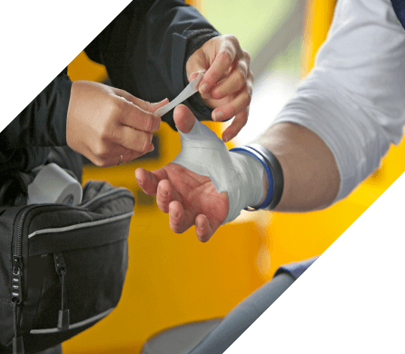 Sports caregiver using athletic tape to wrap the wrist and thumb of an athlete