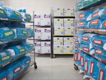 Surgical procedure packs and Complete Delivery Systems are neatly organized on shelves in storage room