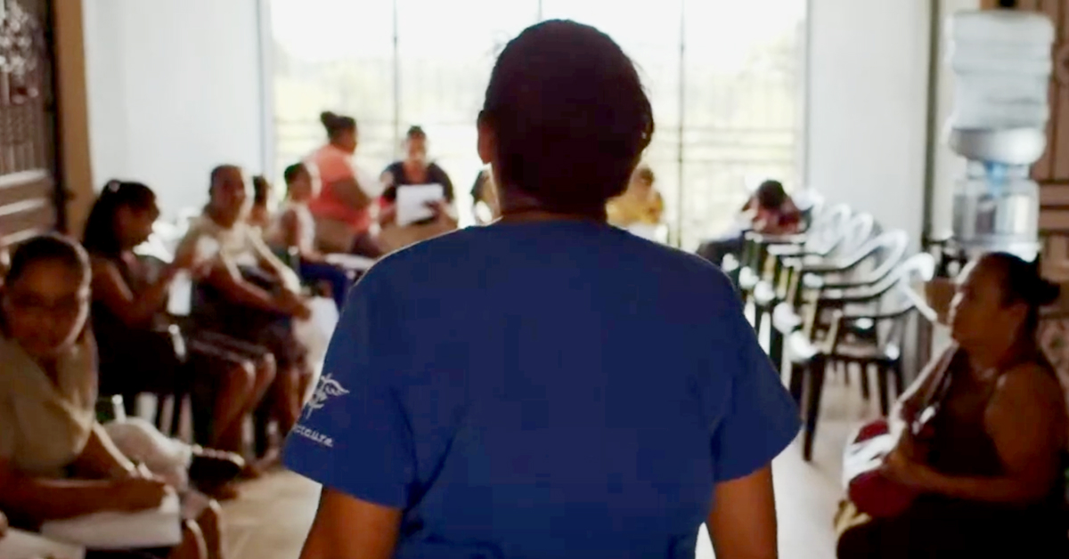 A hospital employee in scrubs looking for patient in waiting room