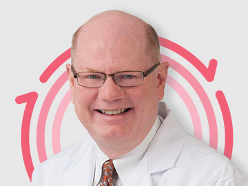 Mikel-Gray Headshot of Dr. Mikel Gray with three pink concentric circles in the background