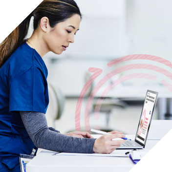 webinar-bnr Nurse in blue scrubs looking at laptop