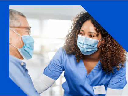 nurse in a mask talking to a patient in a mask