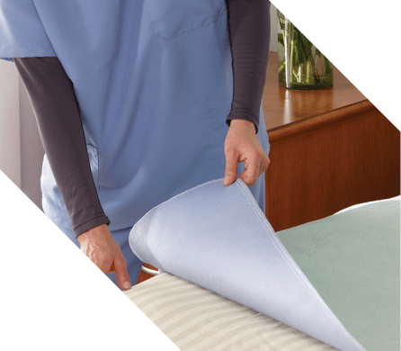 caregiver looking at underpad and lifting the top layer