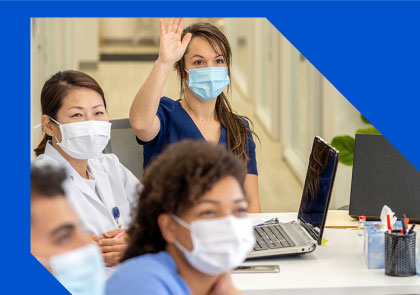 nurses listing to someone and raising their hands
