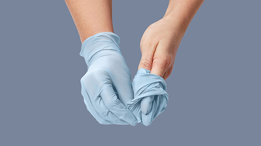 hands taking off exam gloves