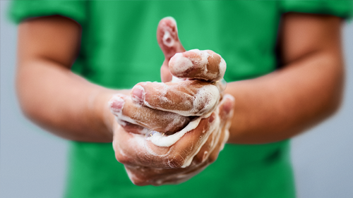Nurse washing hands in green scrubs