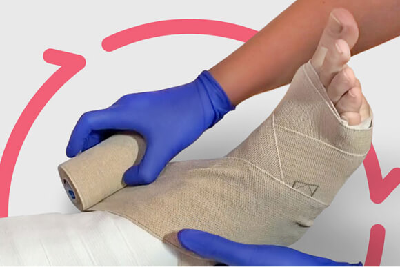 Close up of compression wrap being placed around patient’s foot.