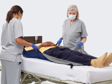fight-skin-1-min Two caregivers prepare to move a patient using a repositioning sheet