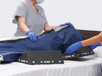 fight-skin-2-min Two caregivers offload pressure using wedges