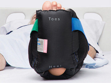heel-screen-printing HeelMedix Advanced Heel Protector with instructional toe/heel printing applied to patient’s heel in hospital bed