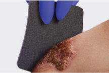 Caregiver’s gloved hands opening up boot to show its lining