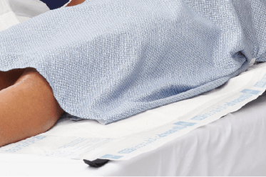 Clinician holds drypad designed to protect against incontinence-associated dermatitis (IAD) caused by urine, stool