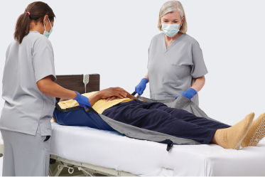 Gloved caregiver hands dispense ISP skin repair cream to patient’s elbow