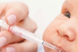 innovation-stratergies-44-min Caregiver administering medication via syringe into infant's mouth