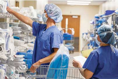 two healthcare workers in a supply room, checking inventory