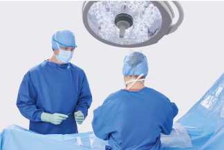 2 surgeons, fully covered, in an operating room under a bright light
