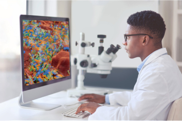 Man looking at computer screen with enlarged image of biofilm