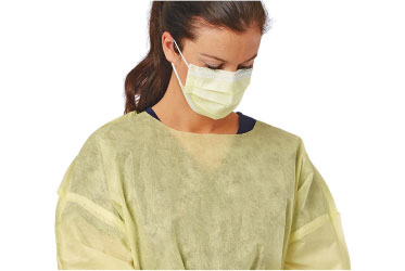 compliant-PPE Healthcare worker looking down wearing a medical mask and full gown.