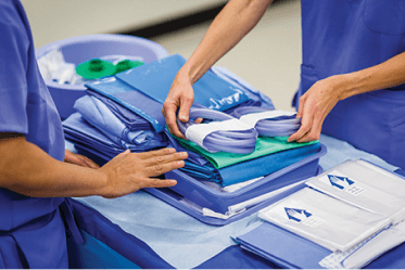 kitting-solutions surgery center workers unpacking a custom kit to prepare for surgery
