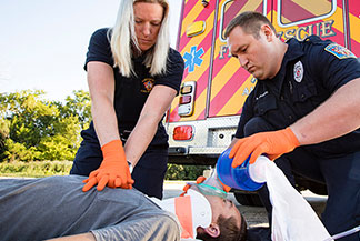 EMS technician administering to a patient on a gurney