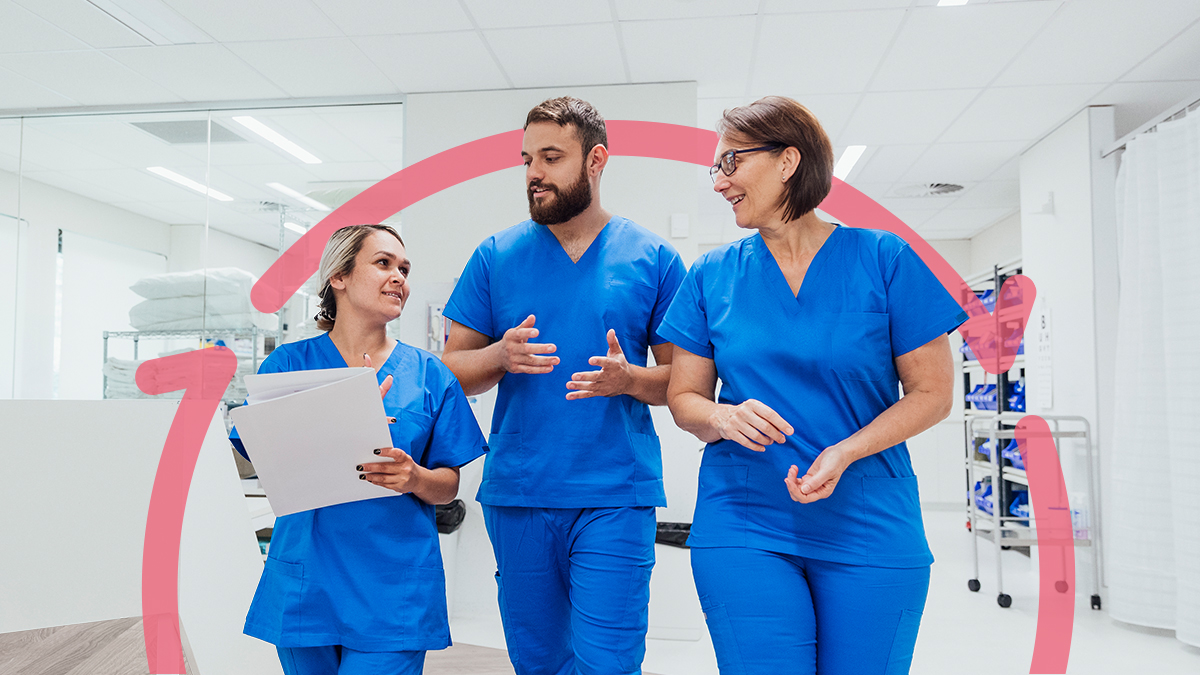 Three clinicians walking and talking in a healthcare facility