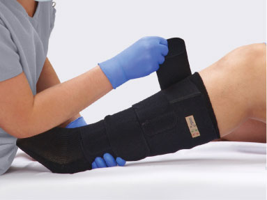 Caregiver’s gloved hands opening up boot to show its lining