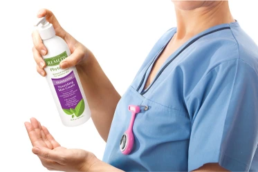 Nurse in PPE in hospital stands next to a wide array of skin care products