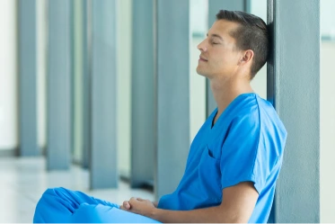 Nurse in PPE in hospital stands next to a wide array of skin care products