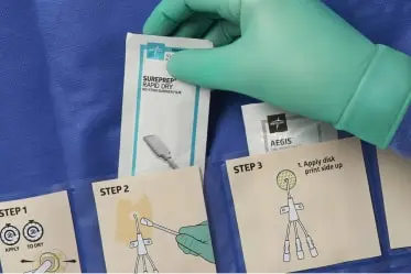 A clinician’s glove hand choose SurePrep rapid dry from a CVC insertion kit.