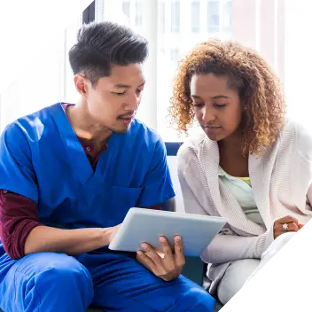 Male clinician explains to a patient using a tablet.