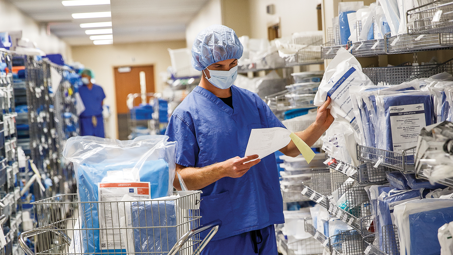 FAC_2015 Medline Stu_6157_02_16-9 Masked clinician inventories devices as part of operating room supply management