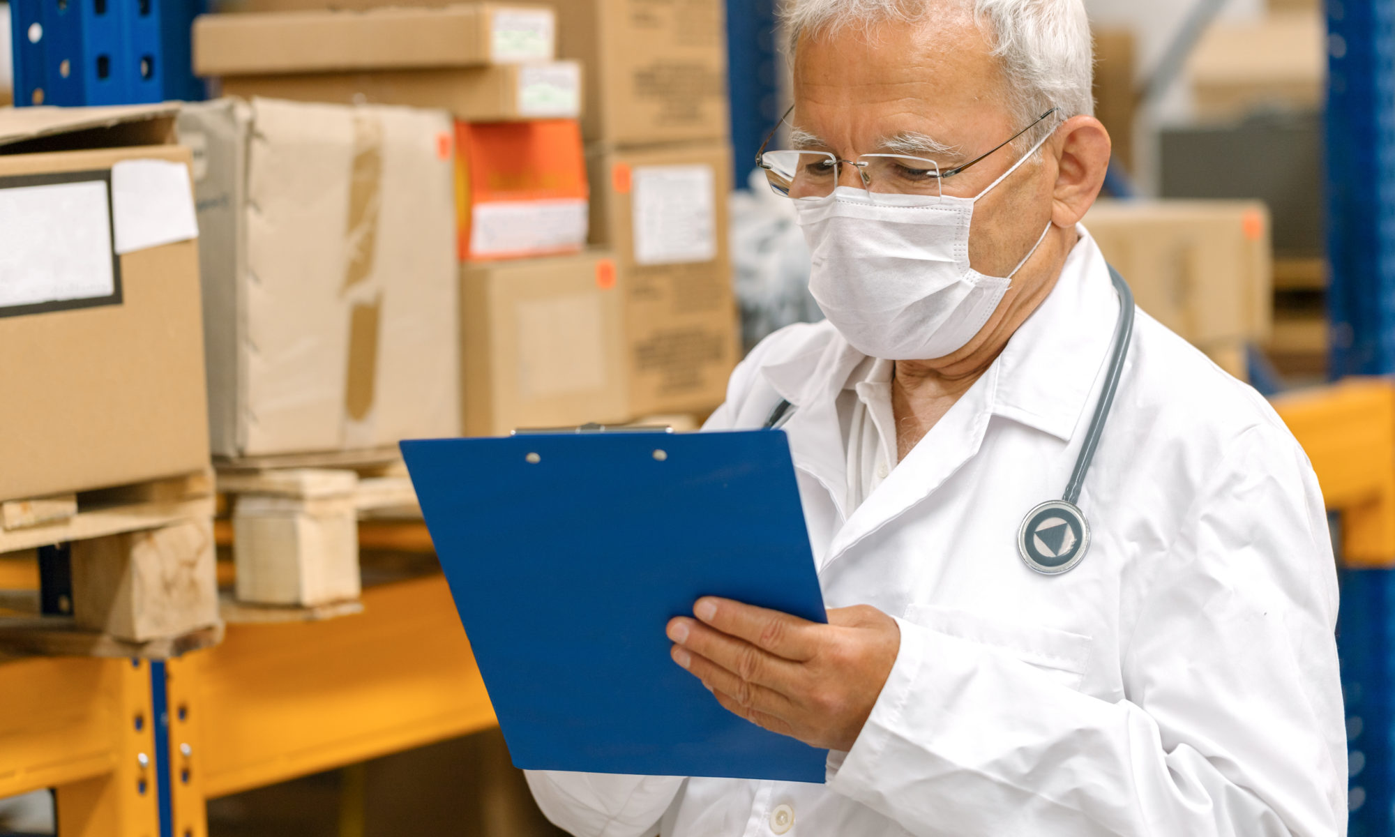 Clinician looks at a clipboard in a supply room