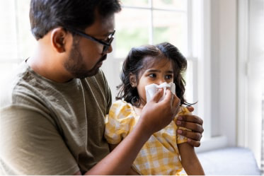 prevention_program_updated father helping daughter blow her nose