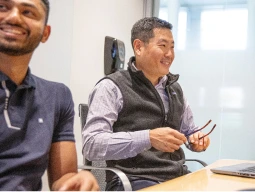 Three men and one woman sitting at a conference table