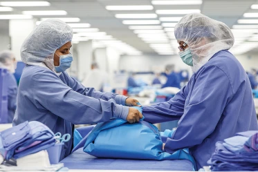 Woman wearing protective gear while working at a Medline manufacturing facility