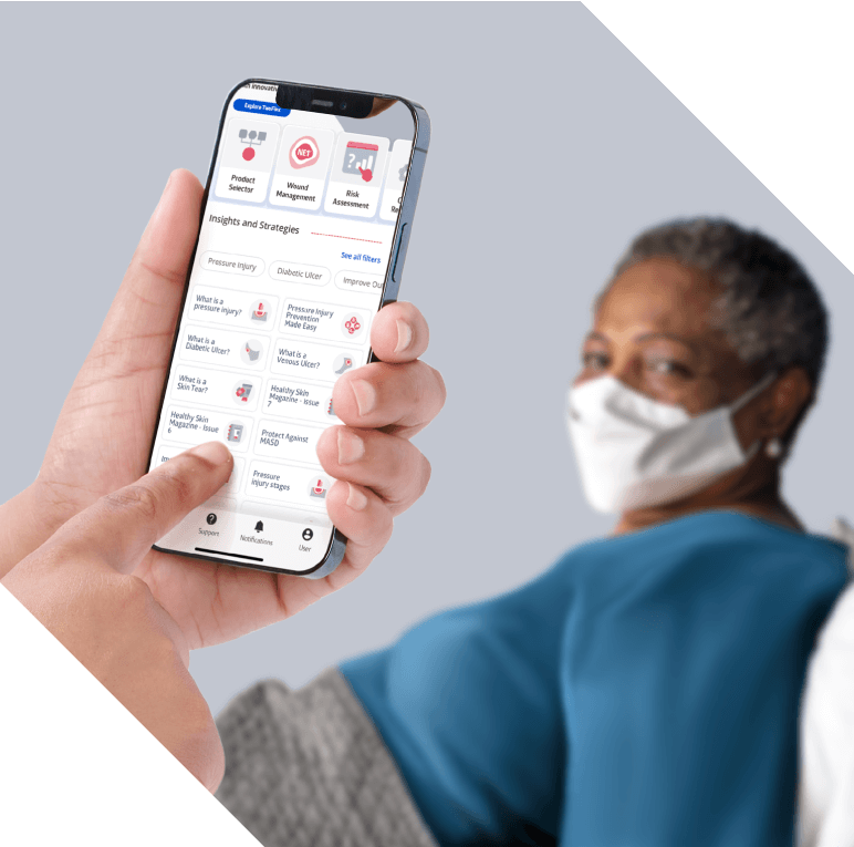 Caregiver uses Skin Health digital platform to inform bedside care beside a bedridden patient