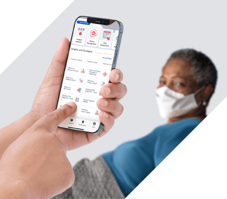 skin-health-digital-platform Caregiver uses Skin Health digital platform to inform bedside care beside a bedridden patient