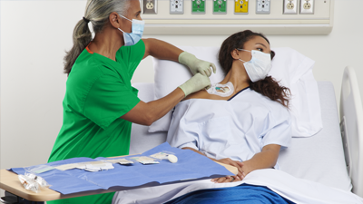 Clinician maintaining a central line on a patient in an acute setting