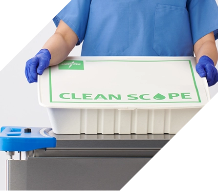 esg_responsible_products_desktop_banner Gloved employee in blue scrubs holding environmentally friendly Clean Scope box.
